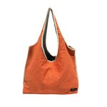 Reversible upcycled tote bag in vibrant orange, showcasing eco-friendly fashion and handmade design.